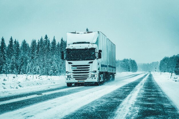 A semi truck removing ice while driving down a snowy road using propylene glycol.